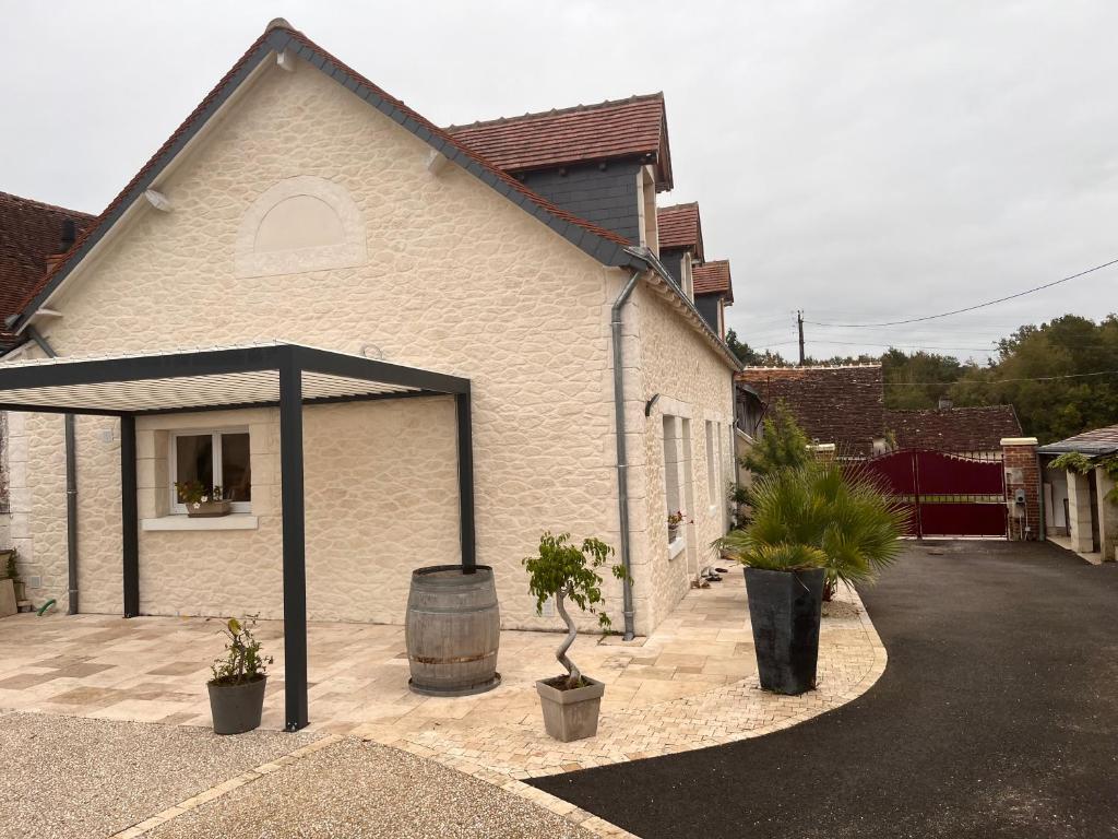 un bâtiment blanc avec un auvent noir à côté d'une rue dans l'établissement Gîte de villiers, à Saint-Julien-de-Chédon