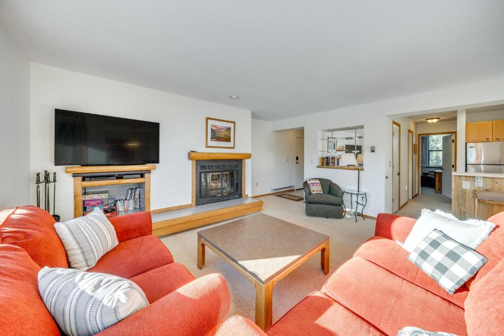 a living room with orange furniture and a flat screen tv at 2 Mi to Winter Park Resort: Condo w/ Pool Access! in Winter Park