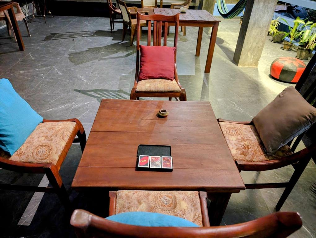 a wooden table and chairs with a cell phone on it at Costels Mirissa in Mirissa