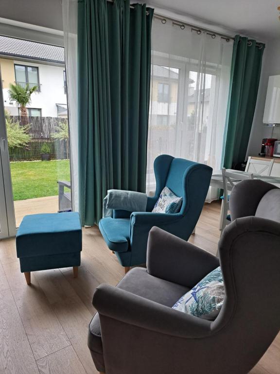 un salon avec deux chaises et un canapé dans l'établissement Dom nad morzem, basen, plaża, siłownia, plac zabaw, kort tenisowy, à Ustronie Morskie