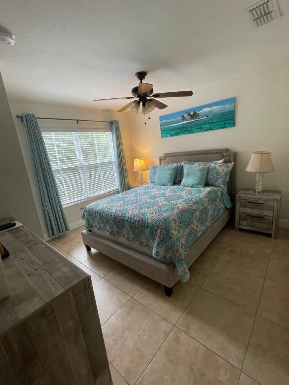 Un dormitorio con una cama y un ventilador de techo. en Venetian Bay Villages, en Kissimmee
