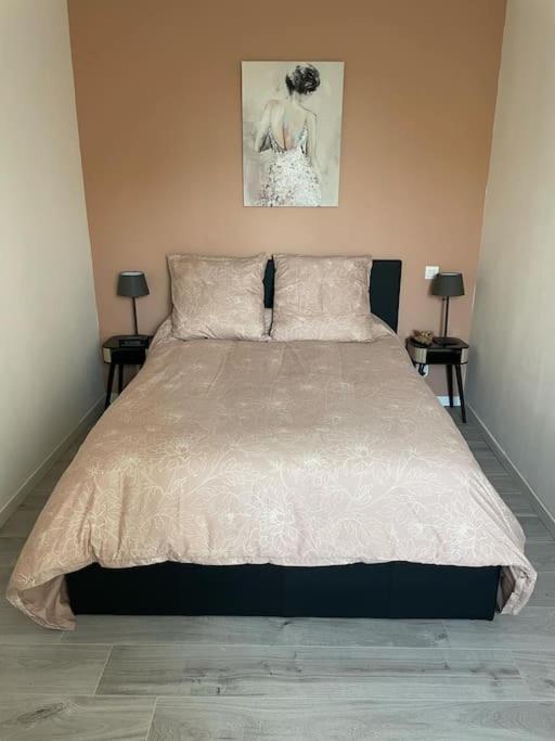 une chambre avec un grand lit avec deux lampes dans l'établissement Maison de village, à Montpezat