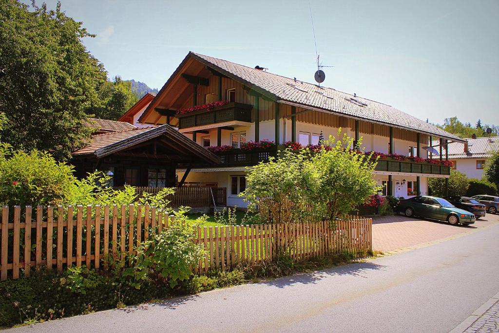 une grande maison avec une clôture devant elle dans l'établissement Pension Weigert, à Bodenmais