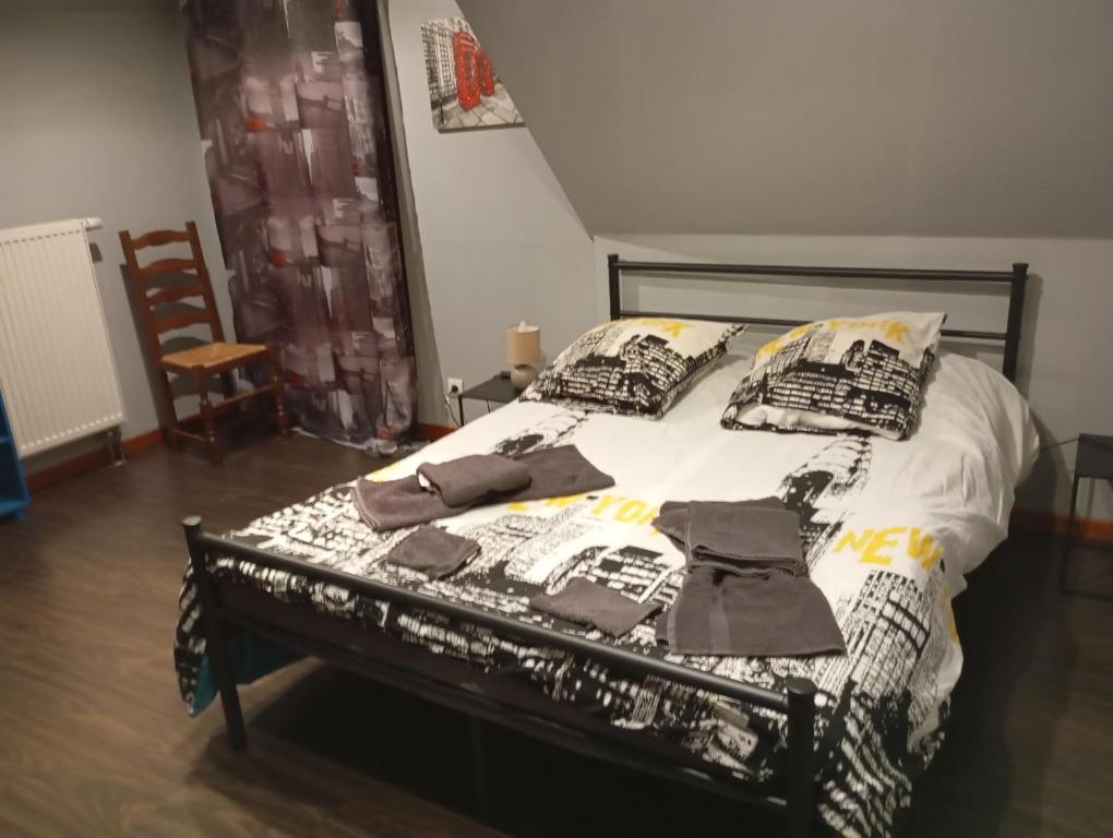 une chambre avec un lit recouvert de vêtements dans l'établissement Cottage champêtre, à Marmoutier