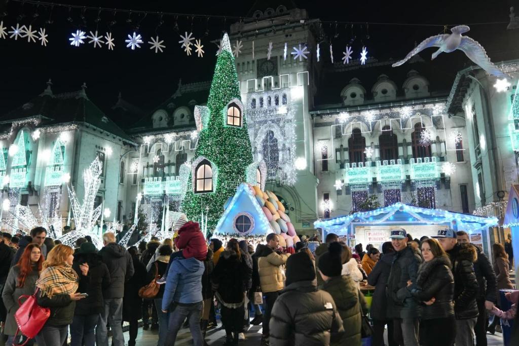 a crowd of people standing in front of a building with christmas lights at Apartament City Center Craiova in Craiova