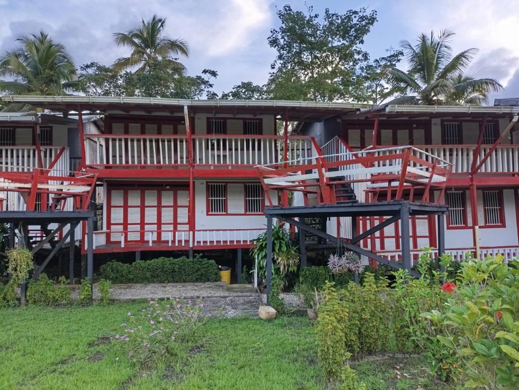 a large red and white building with a yard at Ecohotel Punta Roca in El Valle