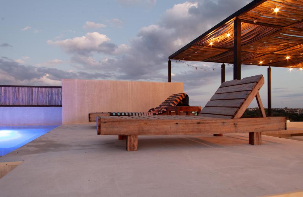 a couple of lounge chairs sitting on top of a roof at The Teodoro in Tulum
