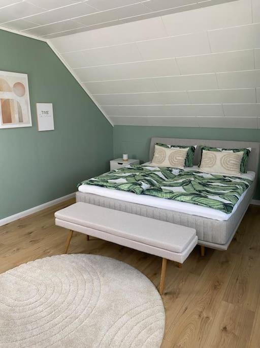 a bedroom with a bed with a green blanket at Ferienwohnung Kleine Auszeit in Pulheim