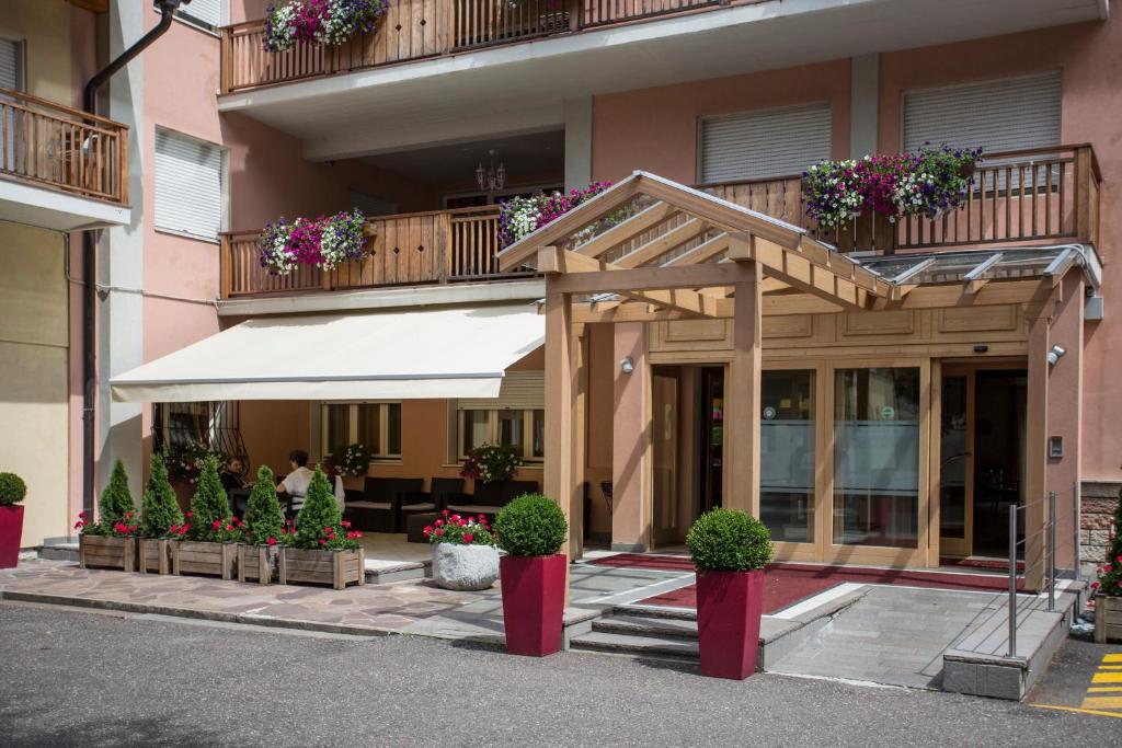 a building with an awning and potted plants at Park Hotel Sacro Cuore in Cavalese