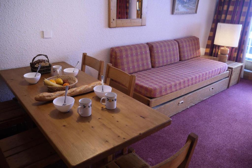 un salon avec une table en bois et un canapé dans l'établissement Résidence Arpasson - ARPASSON 45 MAE-4141, à Les Allues