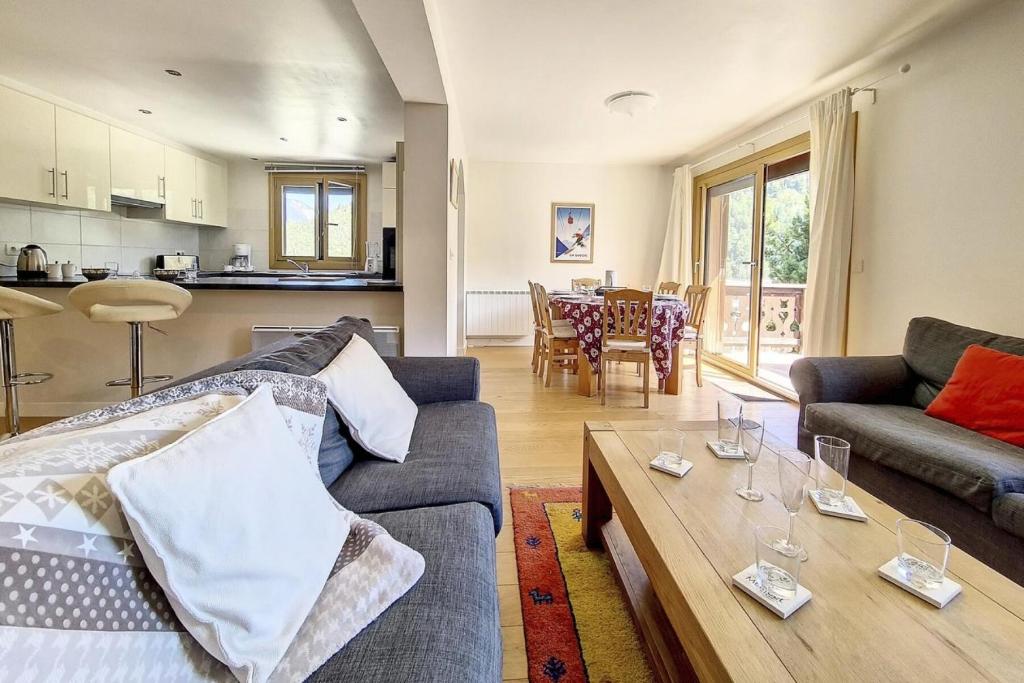 a living room with a couch and a table at Chalet Les Lutins - Un cocon élégant au cœur des Allues MAE-4864 in Les Allues