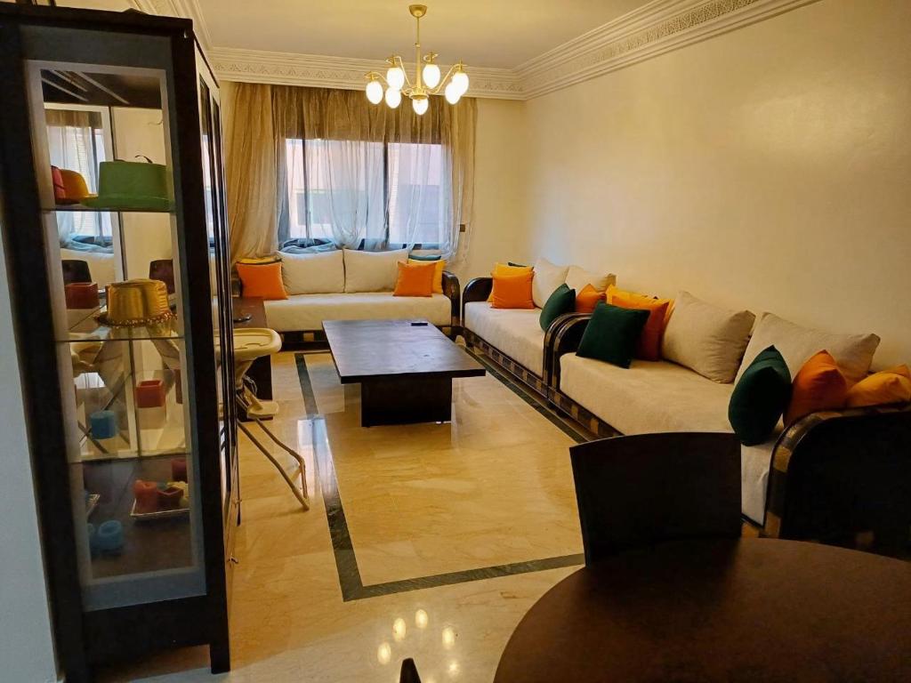 a living room with a couch and a table at Family Apartment with Pool in Marrakech