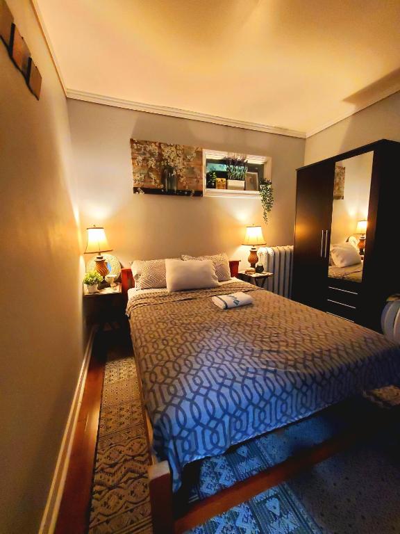 a bedroom with a bed with a blue comforter at Merj's Guest House in Wolesly in Winnipeg