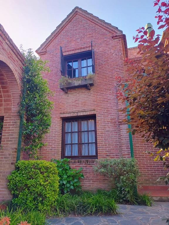 a brick building with two windows and a balcony at Dúplex Aldea in Pinamar