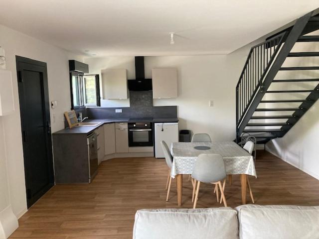 une cuisine et une salle à manger avec une table et un escalier dans l'établissement Charmant appartement de village, à Aniane