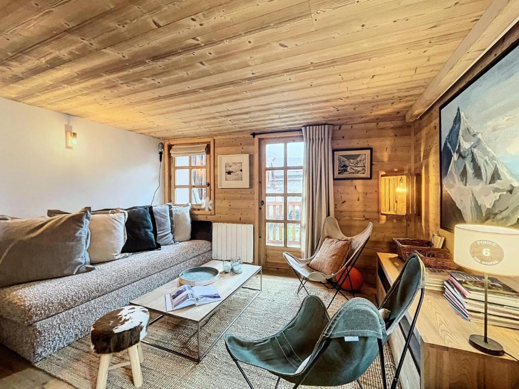 ein Wohnzimmer mit Couch und Stühlen in der Unterkunft Chalet Furz'a - Chalet Familial Cosy à Méribel MAE-7811 in Les Allues