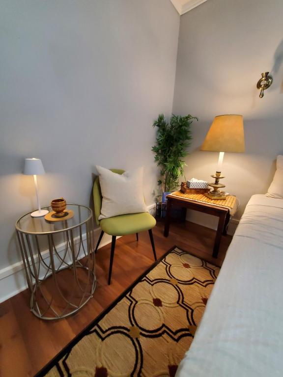 a bedroom with a bed and a table and a chair at Merj's Guest House in Wolesly in Winnipeg