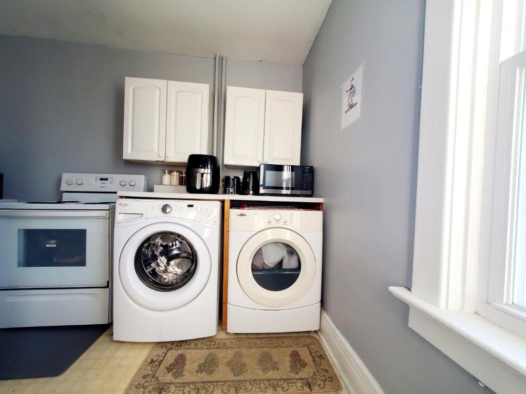 a laundry room with a washer and dryer at Merj's Guest House in Wolesly in Winnipeg