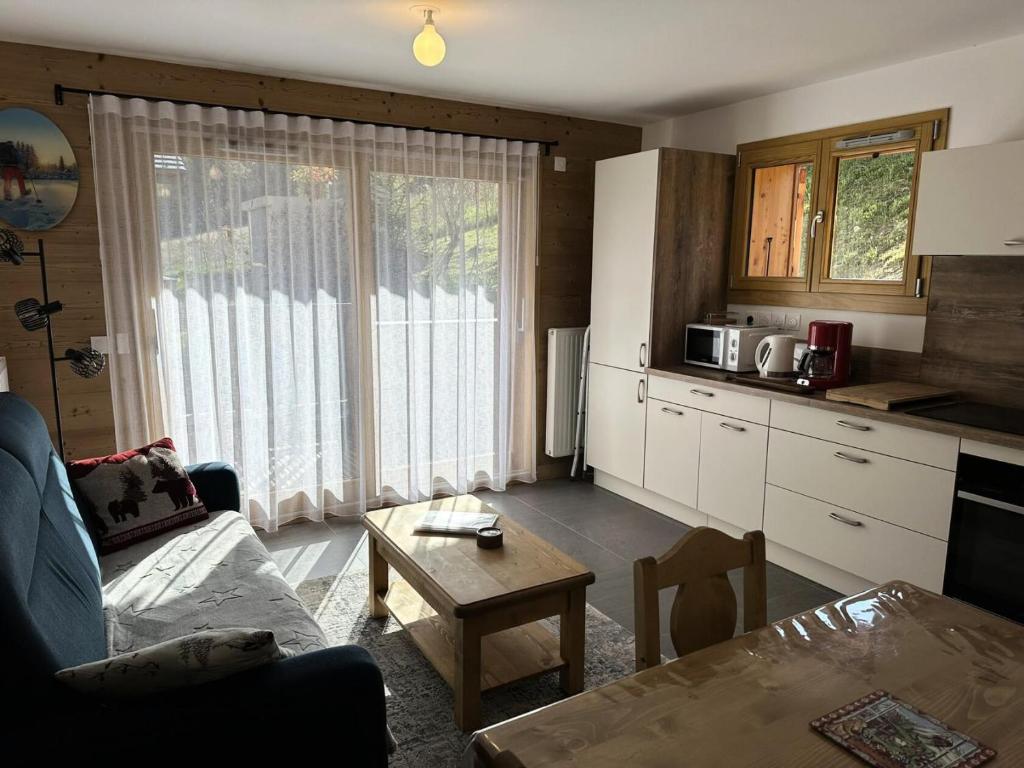 une cuisine et un salon avec un canapé et une table dans l'établissement Chalet Flore - CHALET FLORE MAE-6641, à Combloux