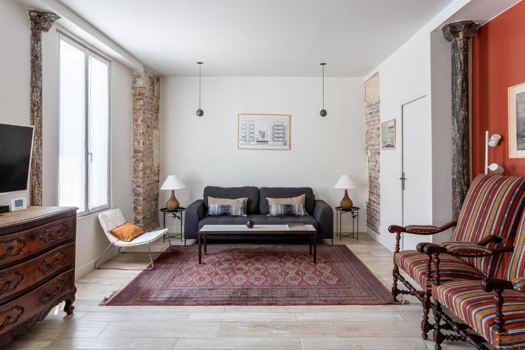 un salon avec un canapé et une télévision dans l'établissement Stade de France & 15min de Montmartre, à Saint-Denis