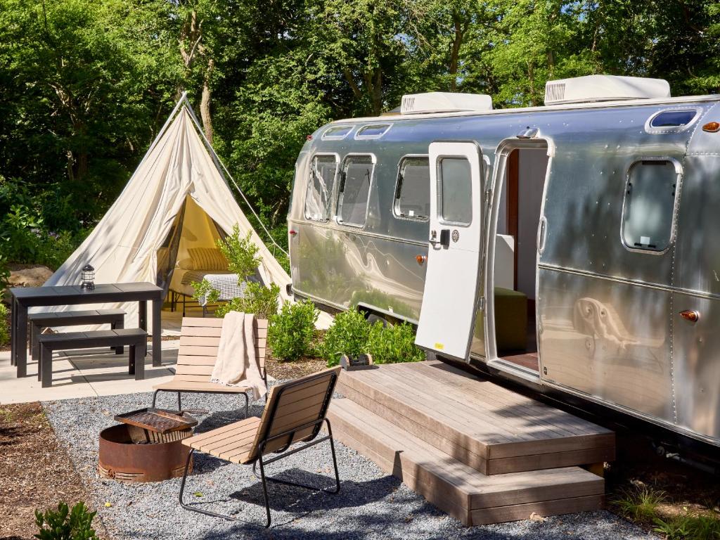 a tent and a table and chairs next to a trailer at AutoCamp Yosemite in Midpines