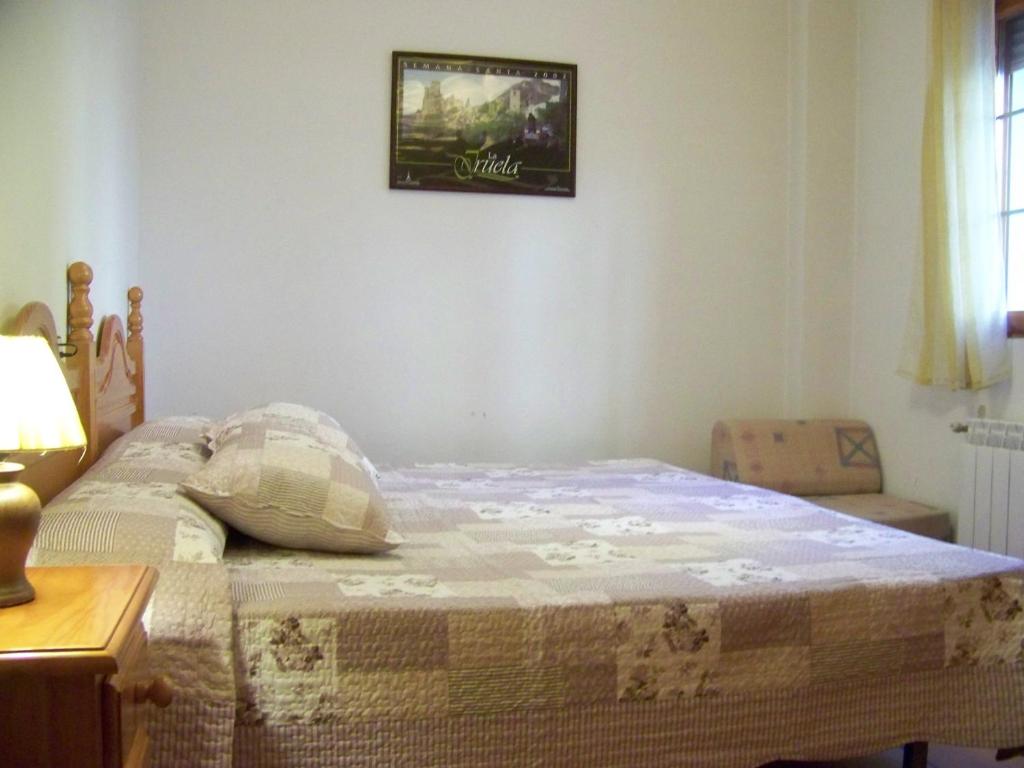 a bed with a quilt on it in a bedroom at Apartamentos La Iruela 2 in La Iruela