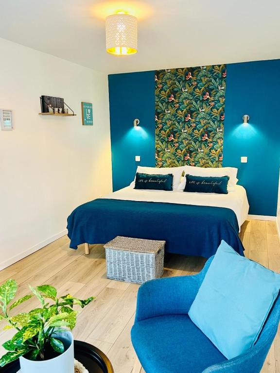 a bedroom with a bed and a blue wall at Studio chic avec parking in Calais
