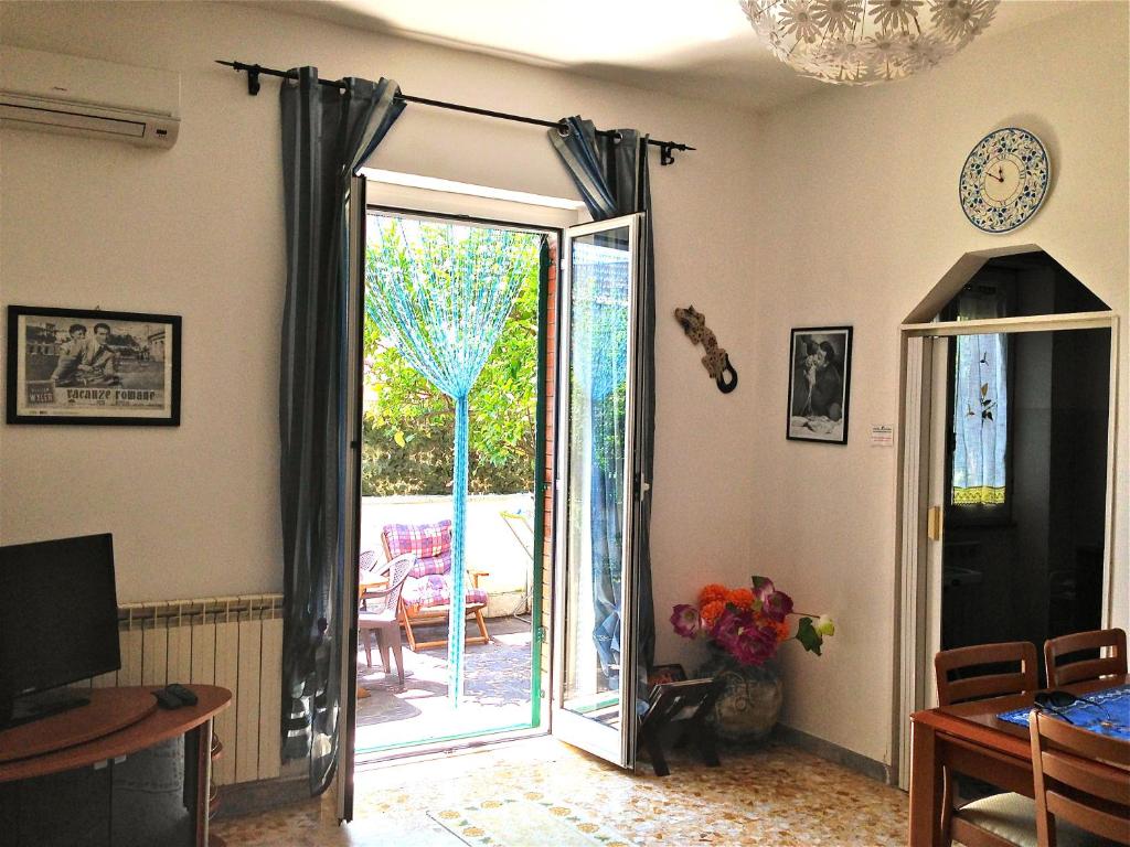 a living room with a door leading to a patio at Ostia Lodge in Ostia Antica