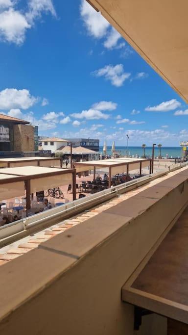 - une vue sur une plage avec des tables et des parasols dans l'établissement Appartement à 20 m de la plage, à Lacanau
