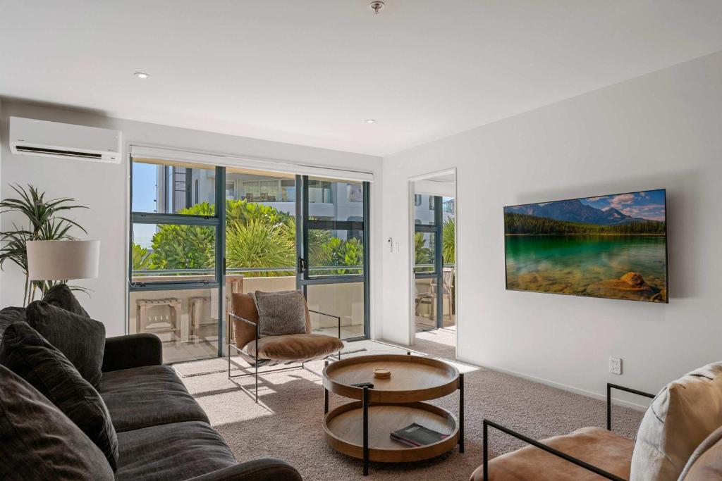 a living room with a couch and a table at Oceanside Retreat Mt Maunganui in Mount Maunganui