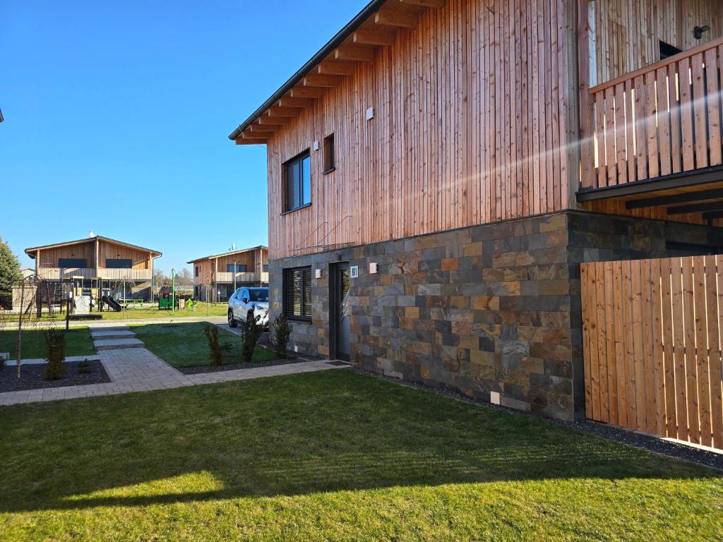 a building with a grass yard next to a house at Hrabušice APARTMENT resort G1 in Hrabušice