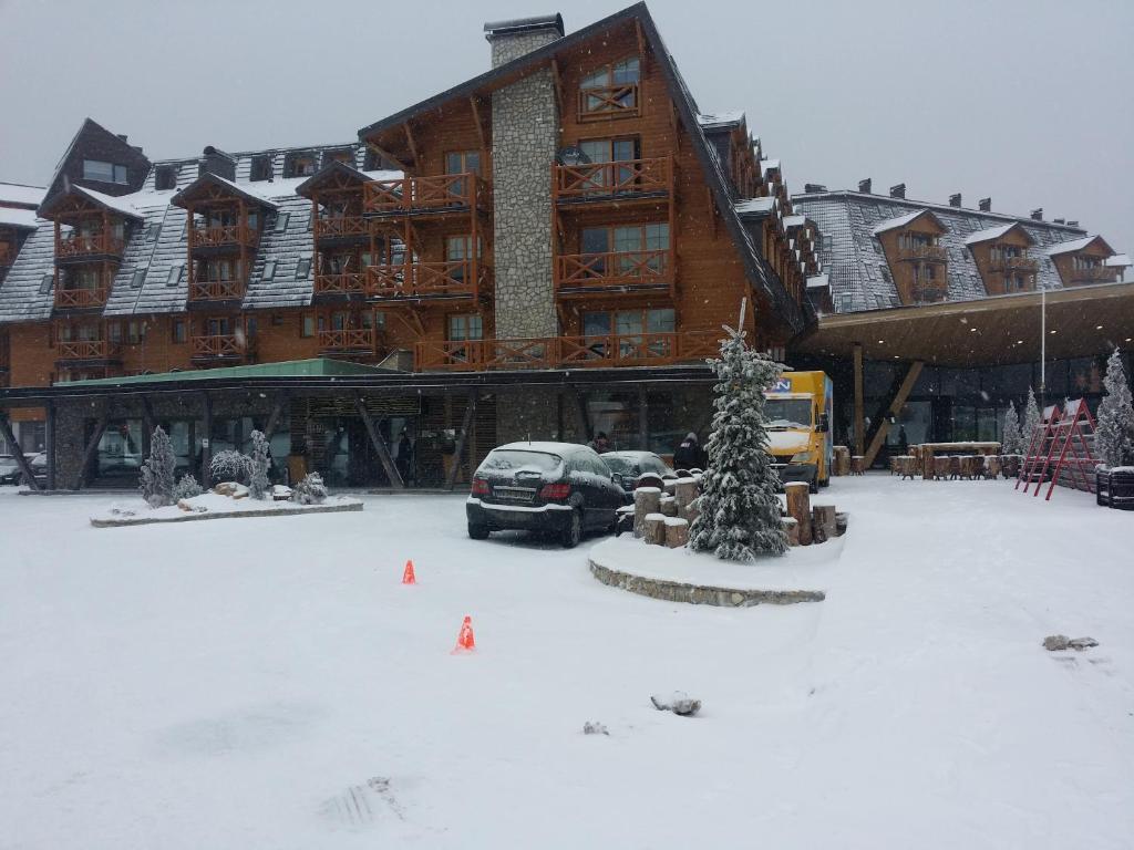 a snow covered parking lot in front of a lodge at Apartment 116 in Jahorina