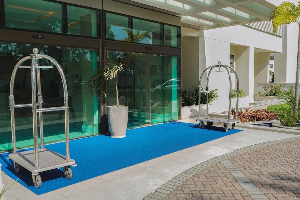 een zwembad met twee metalen driewielers voor een gebouw bij Flat completo próximo ao Rio centro e Arena Carioca in Rio de Janeiro