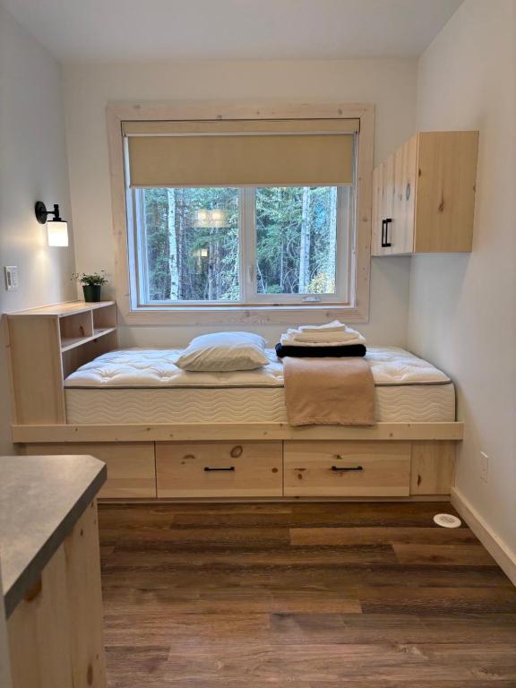 a large bed in a room with a window at Jasper East Hostel - Near Jasper National Park East Gate Entrance in Jasper