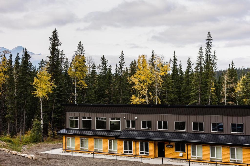 a building in the middle of a forest at Jasper East Hostel - Near Jasper National Park East Gate Entrance in Jasper