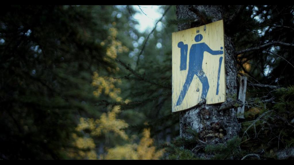 a sign on the side of a tree at Jasper East Hostel - Near Jasper National Park East Gate Entrance in Jasper