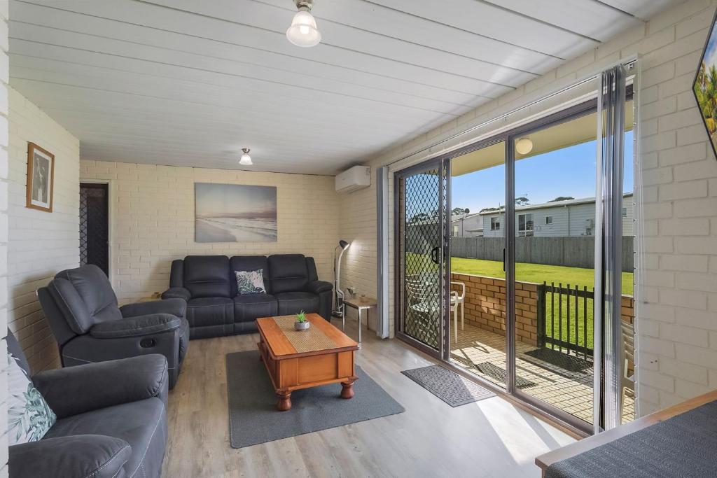 un soggiorno con un divano e un tavolo di Apollo Unit 26 Ground Floor a Narooma