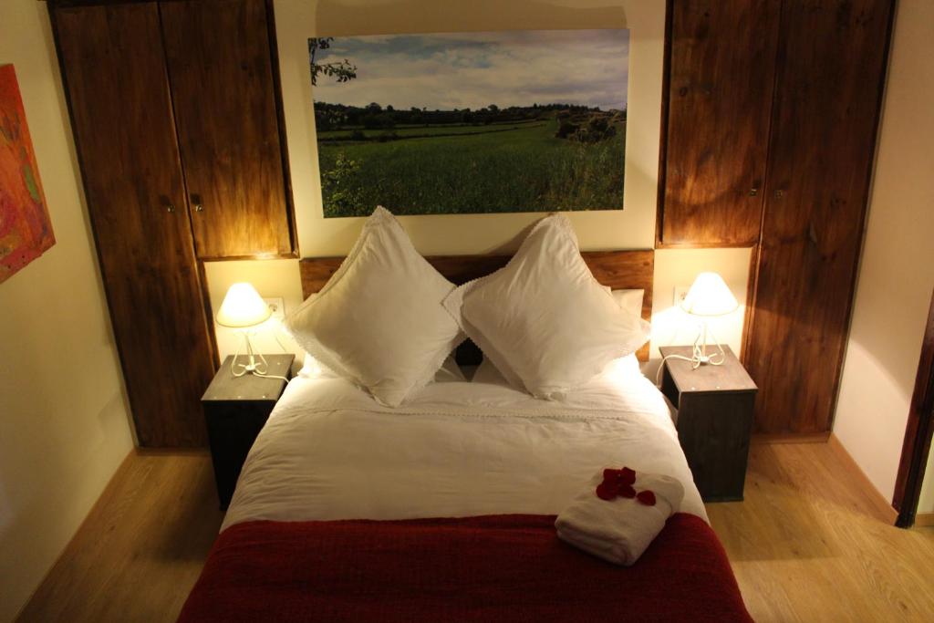 ein Schlafzimmer mit einem großen Bett mit zwei Nachttischen und zwei Lampen in der Unterkunft Casa Rural Las Dalias con Hidromasaje in Villafranca del Cid