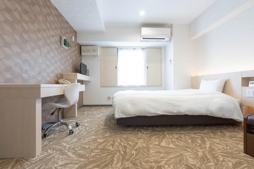 秋田市にあるHotel Alpha Inn Akita - Vacation STAY 67264vのベッドと机があるホテルの部屋