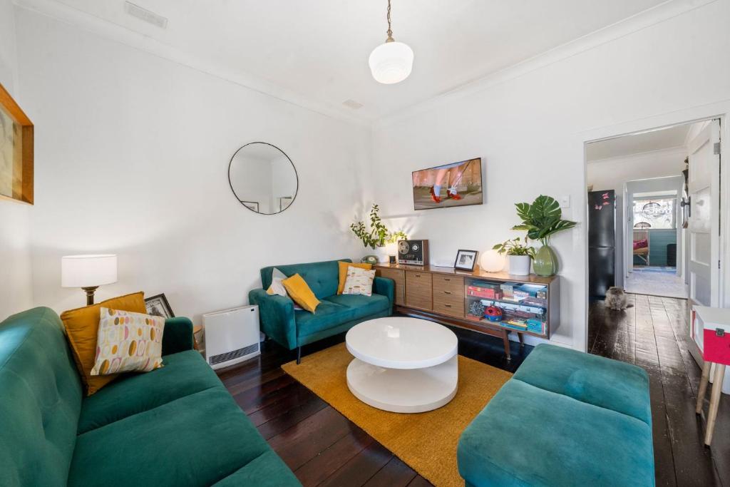 una sala de estar con 2 sofás verdes y una mesa. en Little Red, en Katoomba