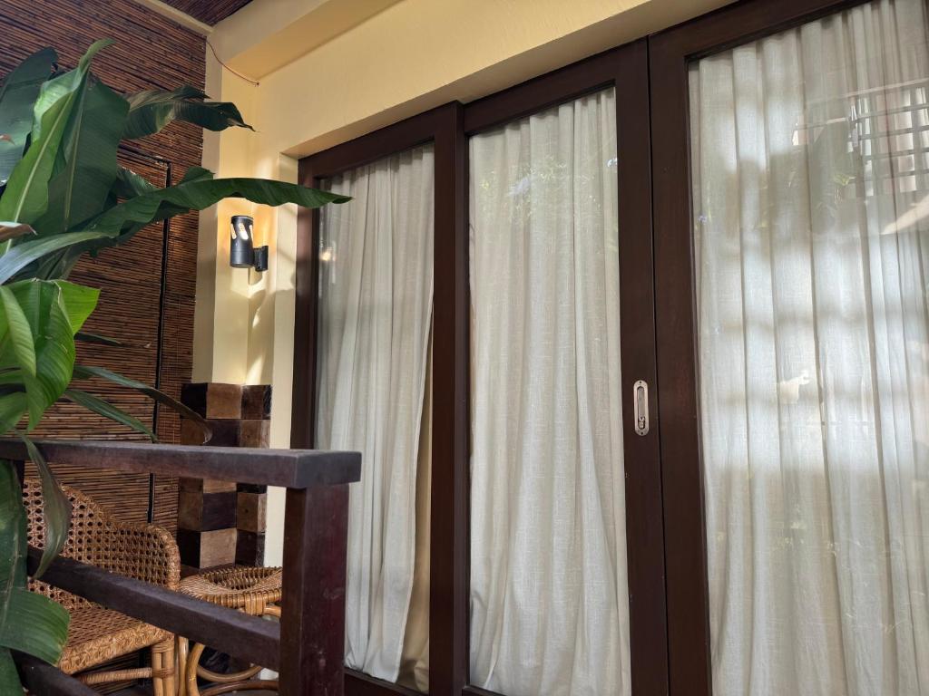 a sliding glass door with white curtains in a room at Caracoa Resort in General Luna