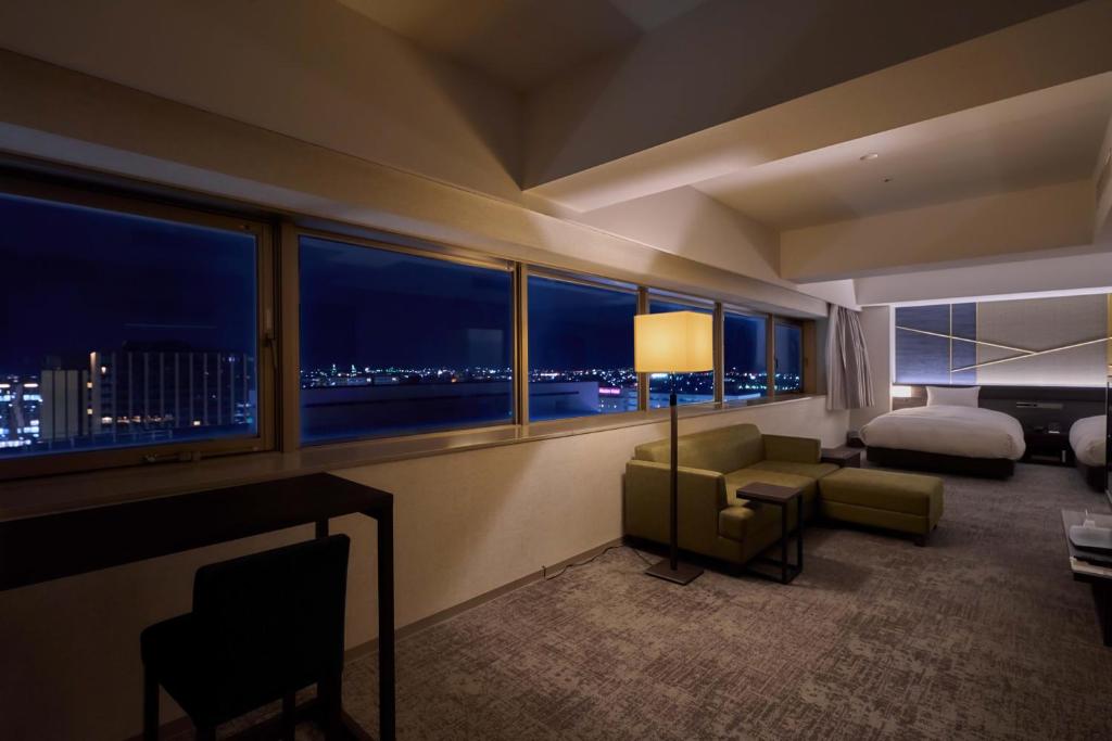 a hotel room with a view of a city at night at Hotel Kanazawa in Kanazawa