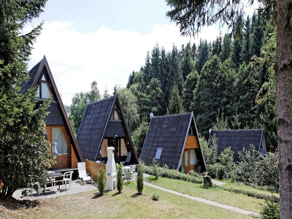 a group of cottages in a forest with trees at Bavarian Hideaway for Families in Waldkirchen