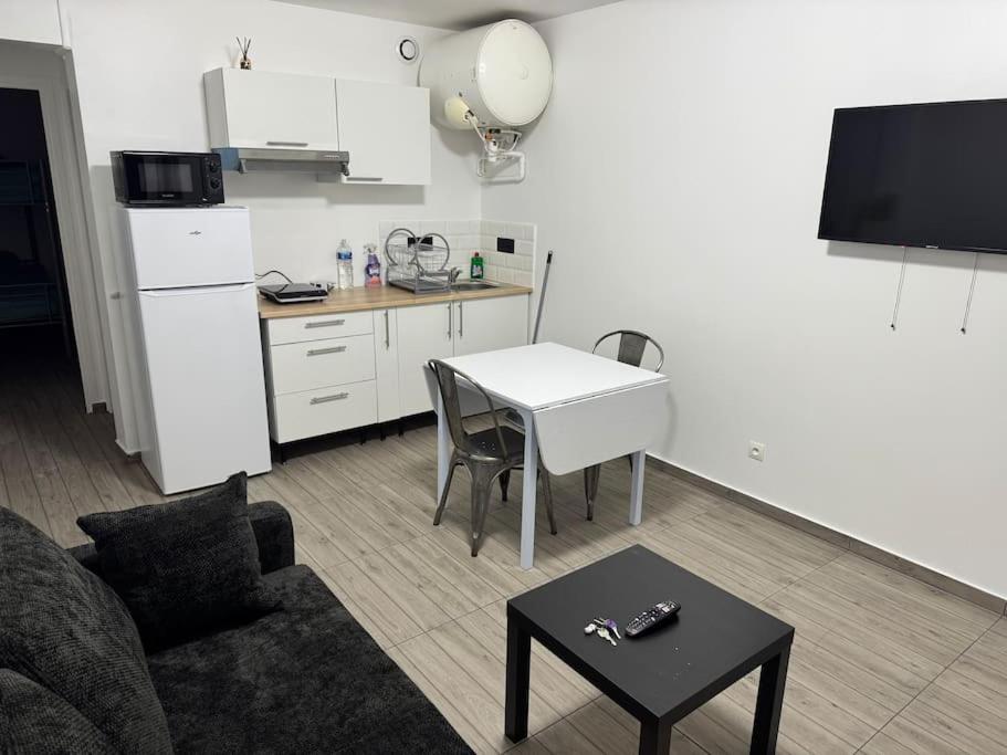un salon avec un canapé et une table et une cuisine dans l'établissement Appartement G, RESIDENCE DU RENOUVEAU, Stade de France, idéal pour 4 pers, à Saint-Denis