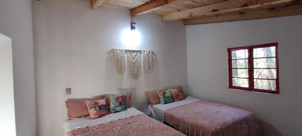 a room with two beds and a window at Cabaña Romeo & Juliett in Juanacatlán