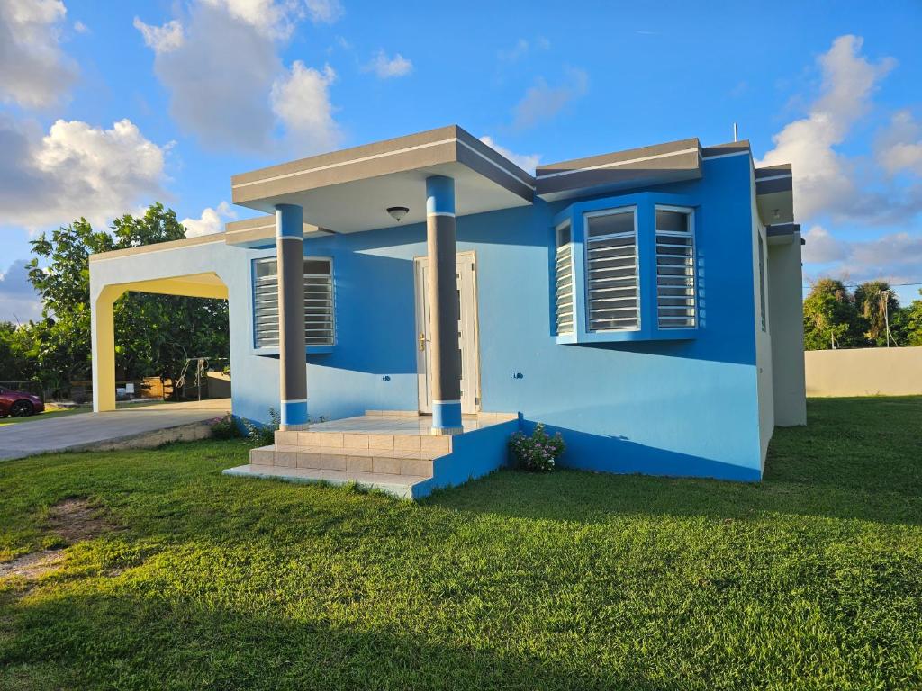 a blue house with a green lawn at Casaplayuela in Camaceyes