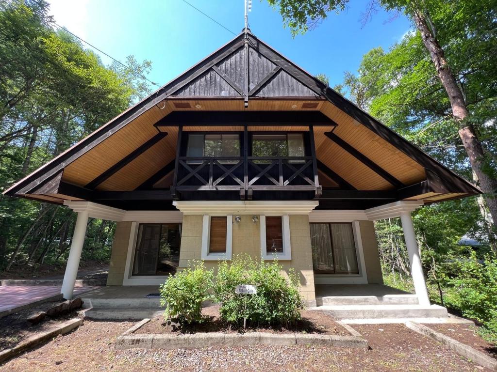 una pequeña casa con techo negro en ネイチャーゲート軽井沢, en Kita-karuizawa