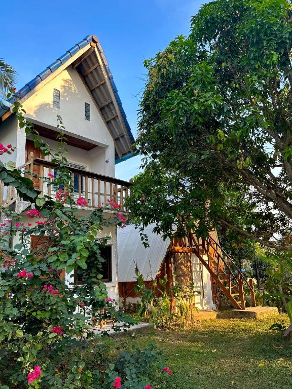 a house with a balcony and a tree at Lazy Bones in Koh Rong Sanloem
