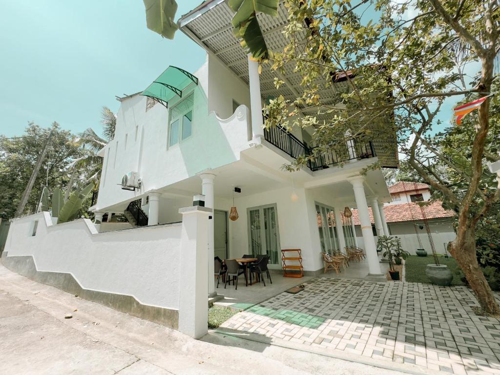 a house with white walls and a patio at Villa Ciana- Private apartment in Unawatuna