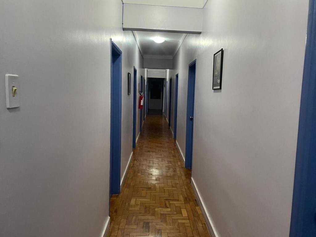 a hallway with blue and white walls and a wooden floor at Hotel Palace Econômico in Goiânia